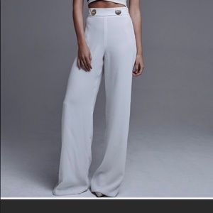White wide leg trousers with two gold buttons